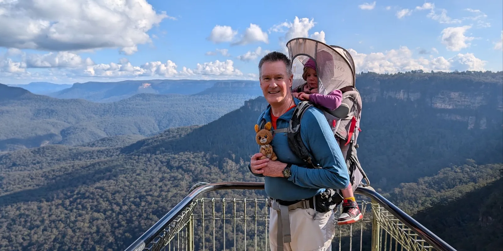 Dad carrying kid in a backpack on a hike
