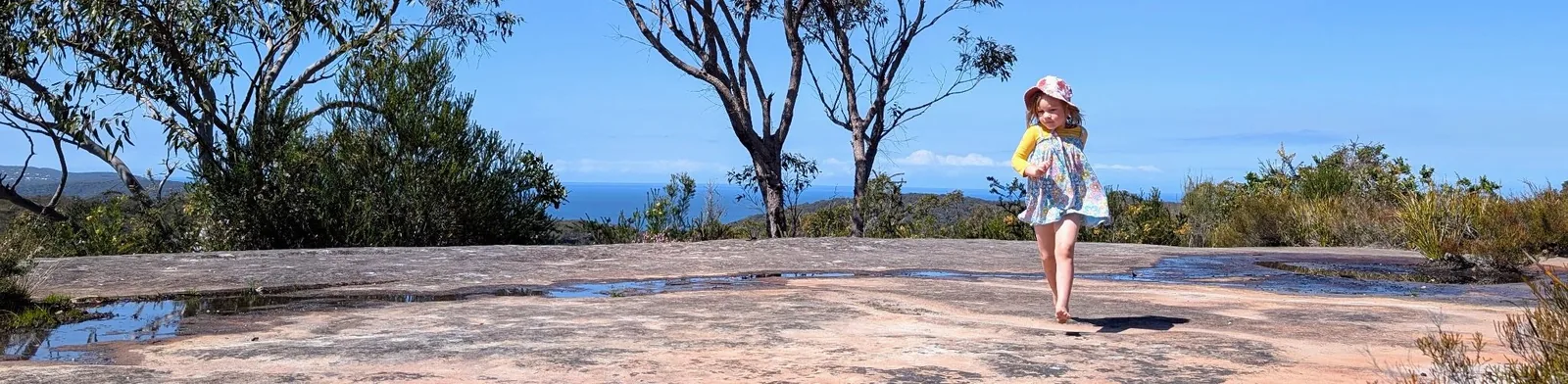 Kid running on a rock platform near waratah trig