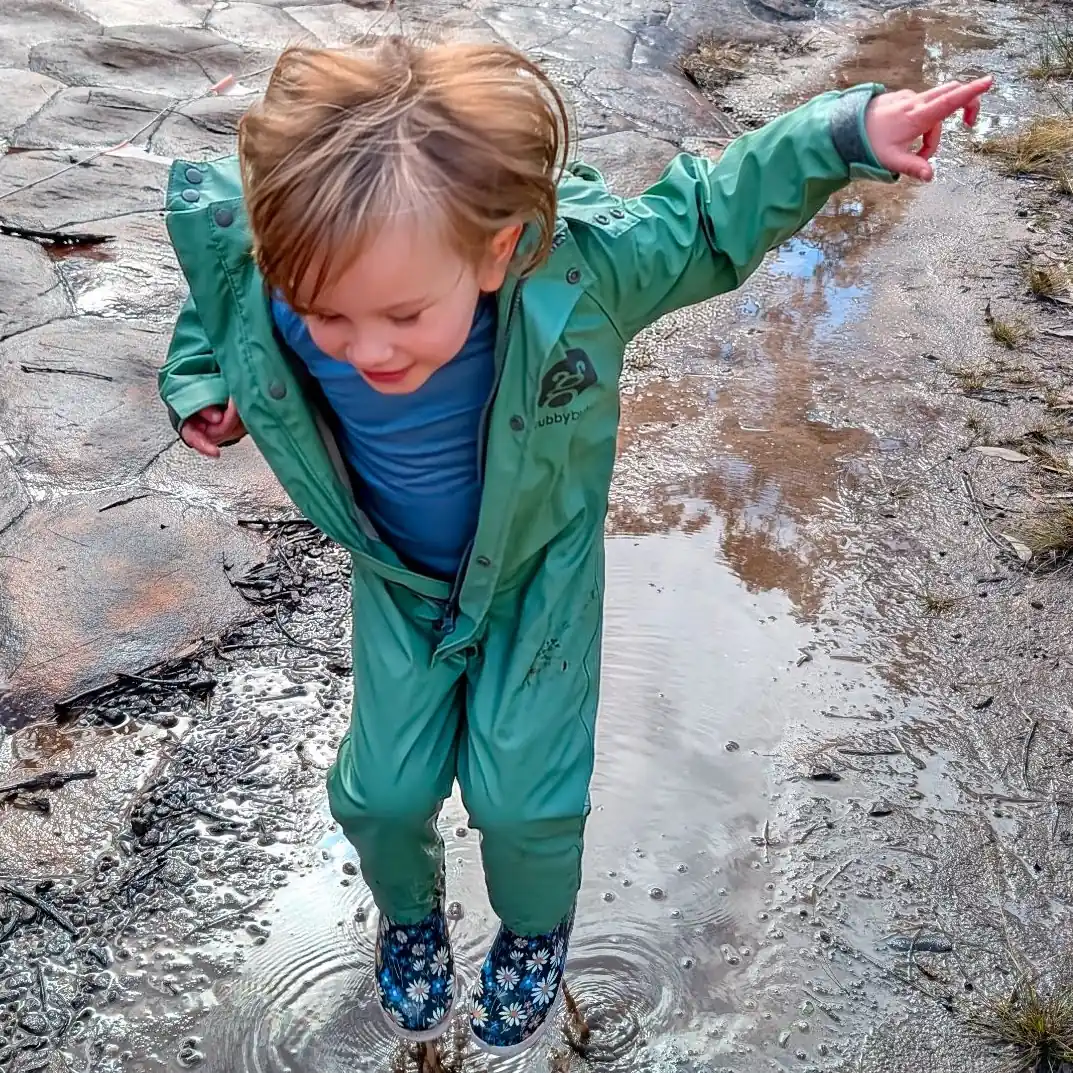 Kid jumping in a puddle