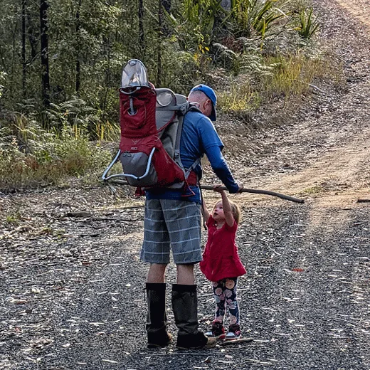 Dad lifting a kid on a stick in a walk